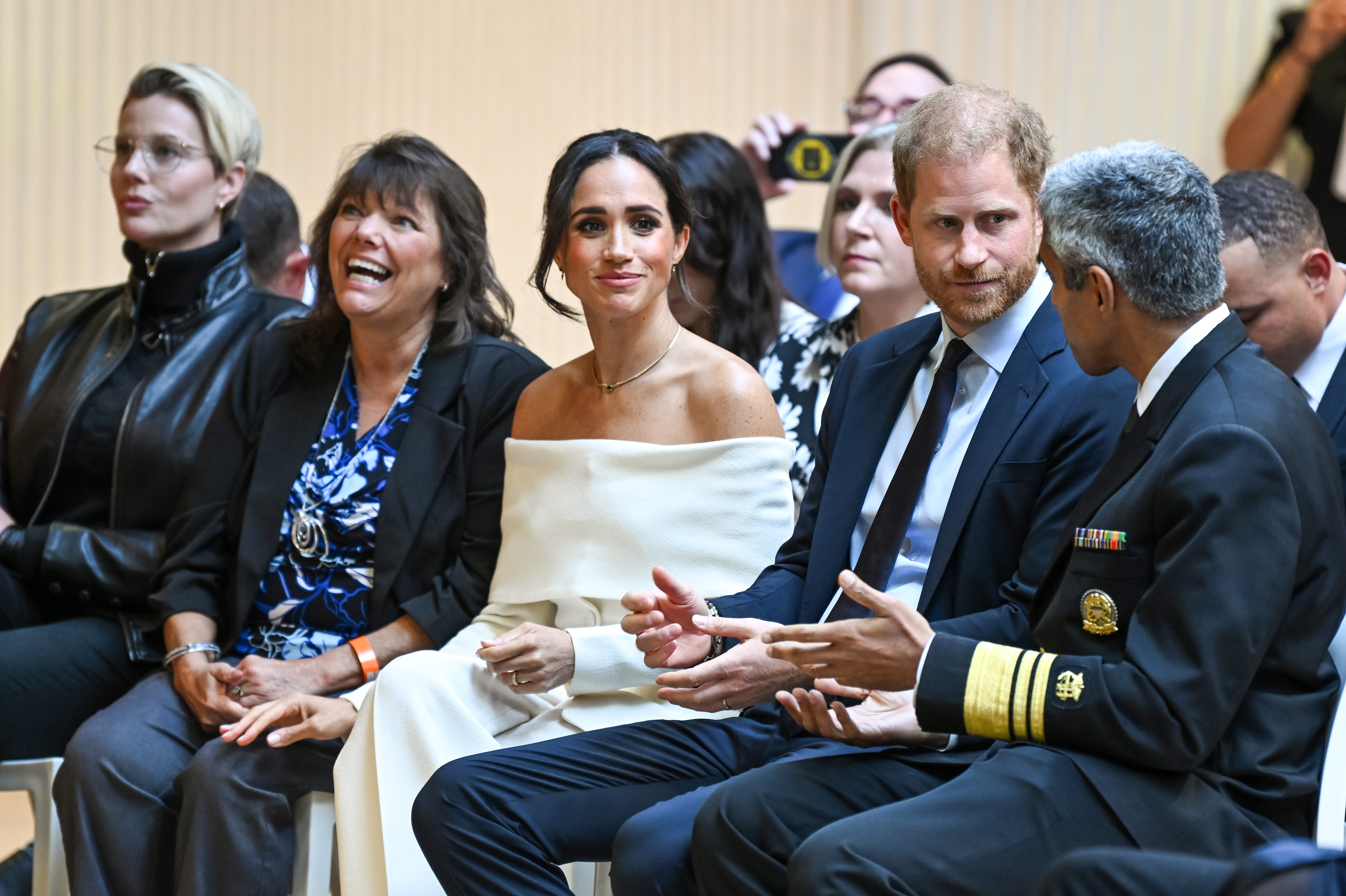 Meghan Markle and Prince Harry sitting in an audience
