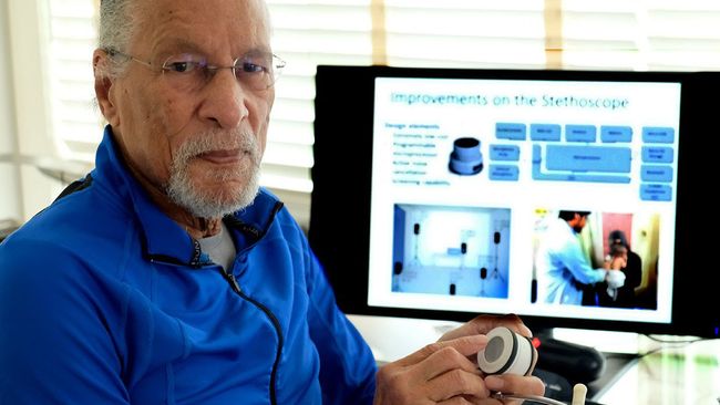 James E. West, 89, is pictured here in 2019 holding one of his team's inventions: a smart stethoscope.