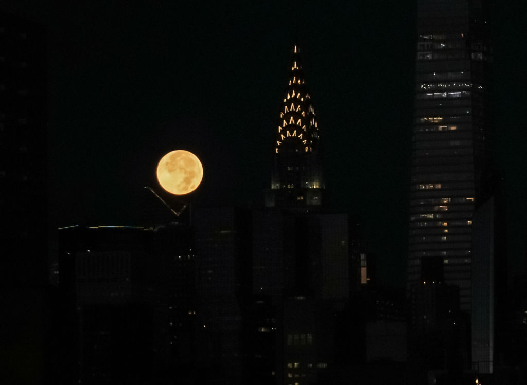 An orange ball next to a dark, barely lit tower