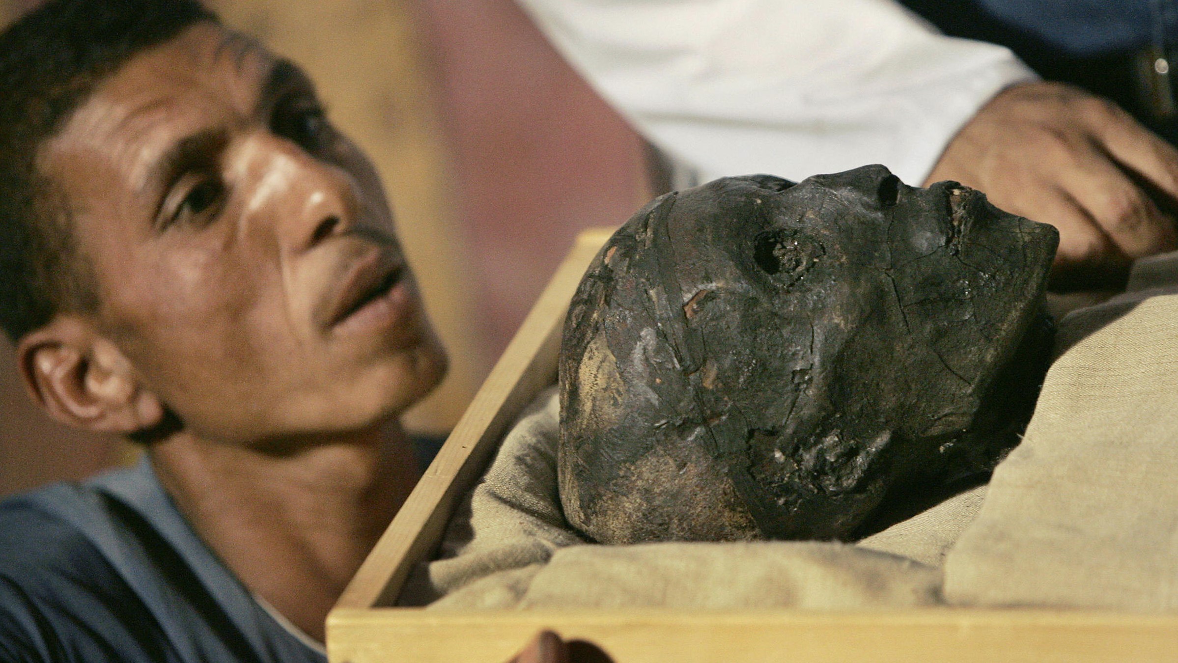An archaeological worker looks at the face of King Tutankhamen in 2007 as the mummy was moved to a climate-controlled case.