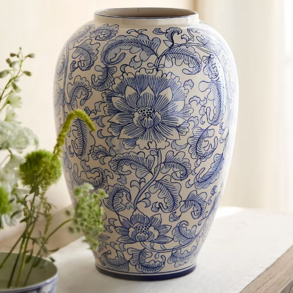 blue and white chinoiserie vase with greenery in foreground