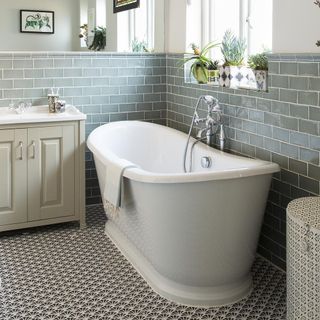 bathroom with grey brick wall and bathtub