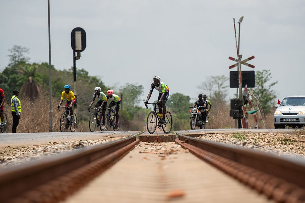 The peloton heads over the railway tracks on the way back towards Lunsar.