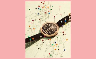 Chanel watch surrounded by pin cushion needles
