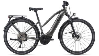 A side view of the Liv Amiti E+ electric hybrid, with flat bars, rear rack, dynamo lights, suspension fork and mid-drive motor