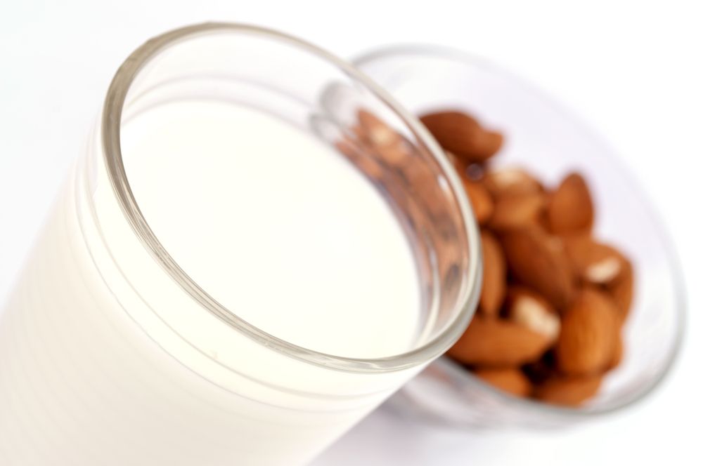 A glass of milk and a bowl of almonds