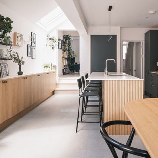 Kitchen with oak and dark green cabinets and white worktops