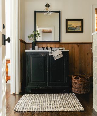 rustic bathroom with black distressed washstand