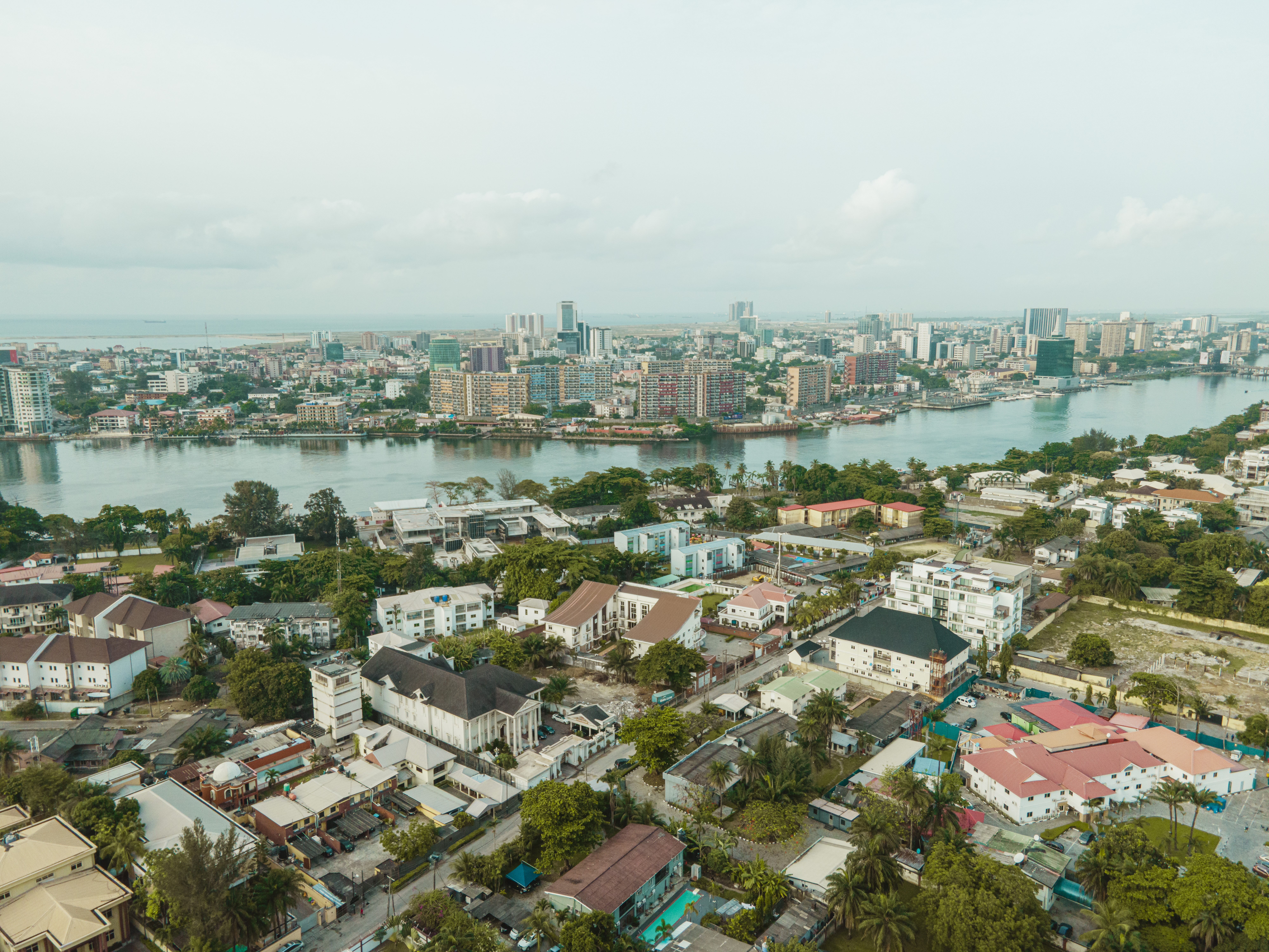 A green city seen from above shows a river running through it and multiple styles of architecture coexisting into one.