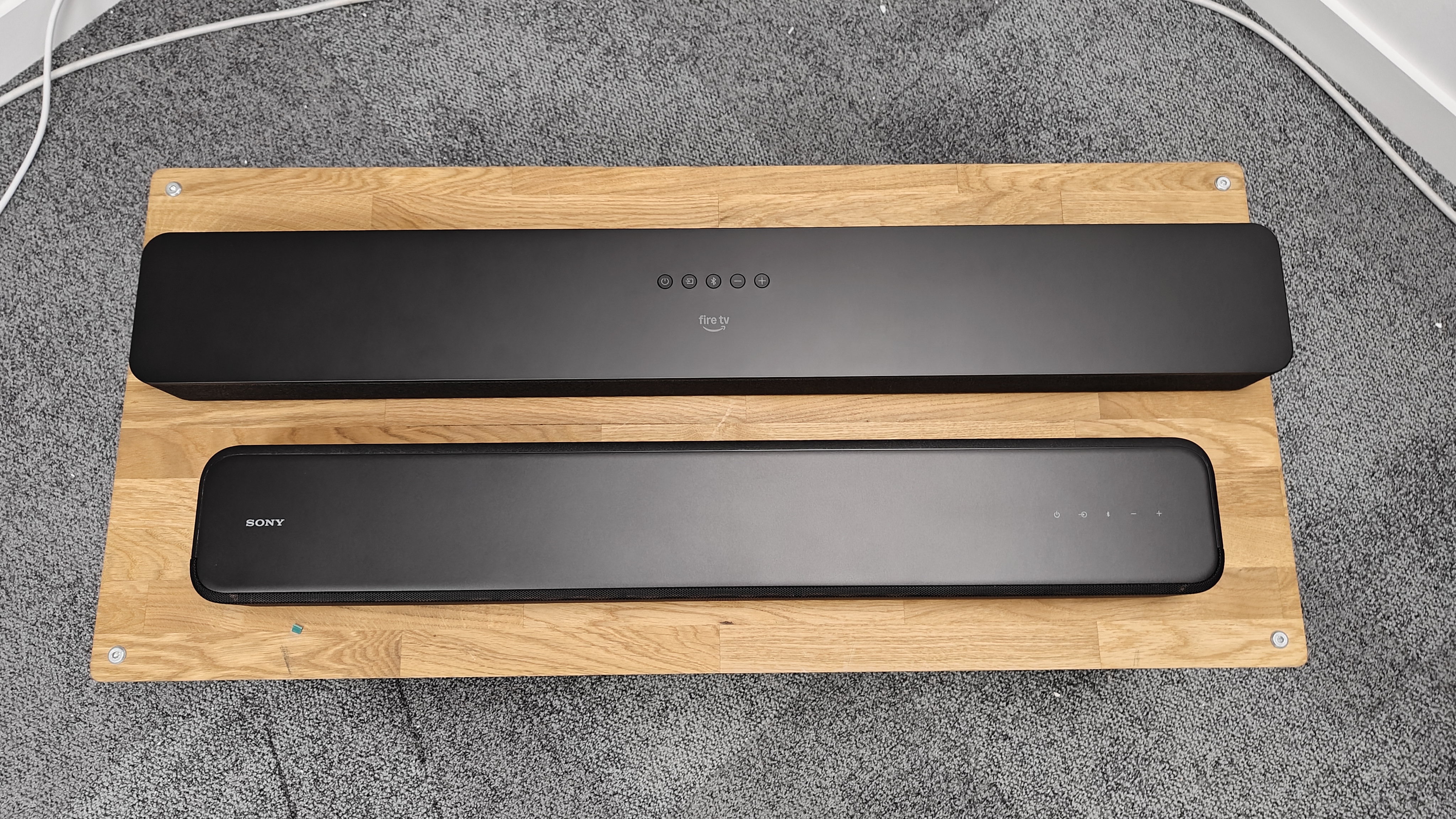 two soundbars on wooden table
