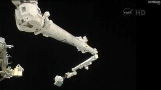 Astronaut Akihiko Hoshide on the space station's robotic arm