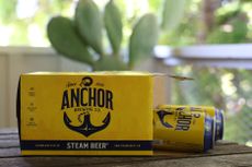 Cans of Anchor Steam beer poking out of a box