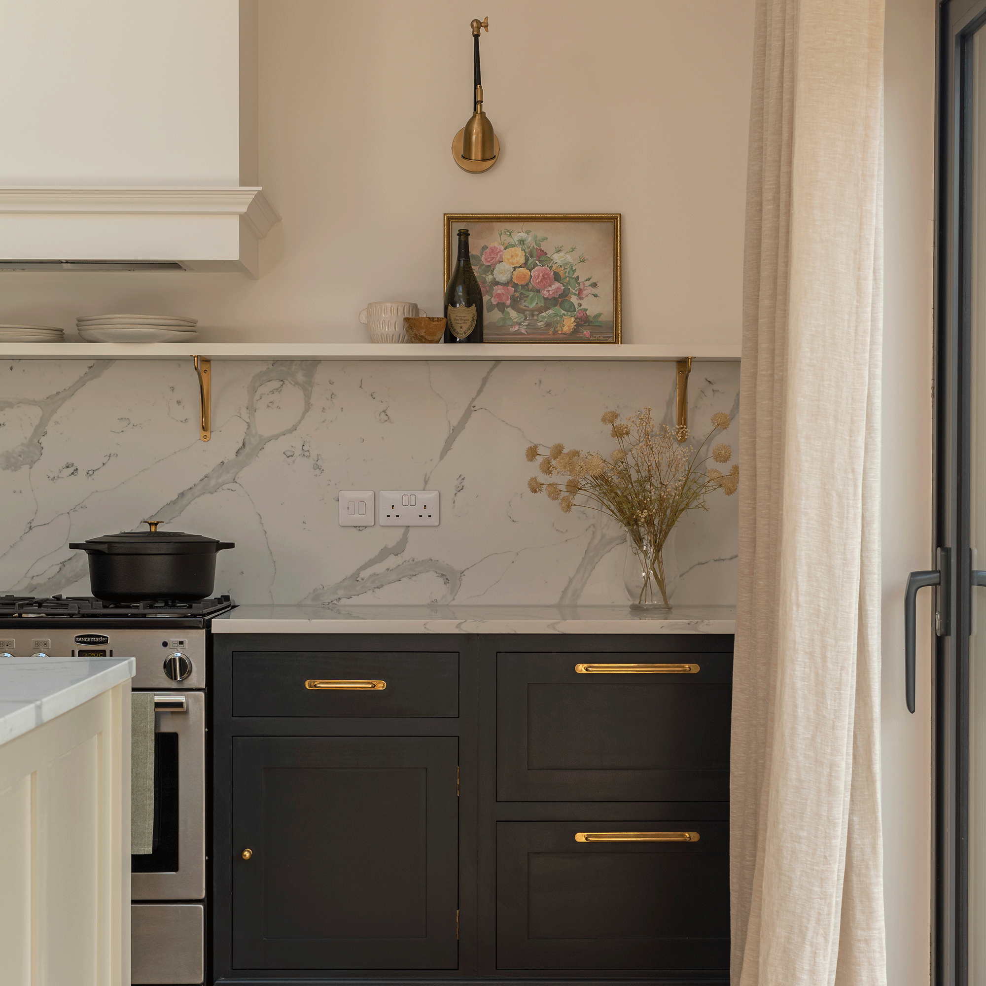 Dark kitchen cabinets with gold handles and beige walls