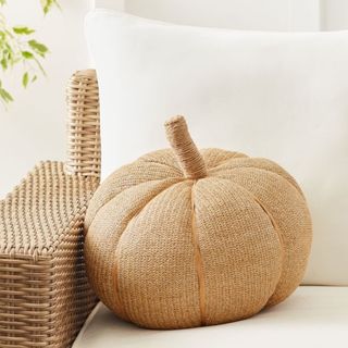 Fall throw pillow pumpkin in beige jute on cream sofa 