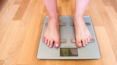 Woman weighing herself on bathroom scales