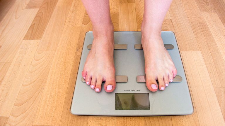 Woman weighing herself on bathroom scales