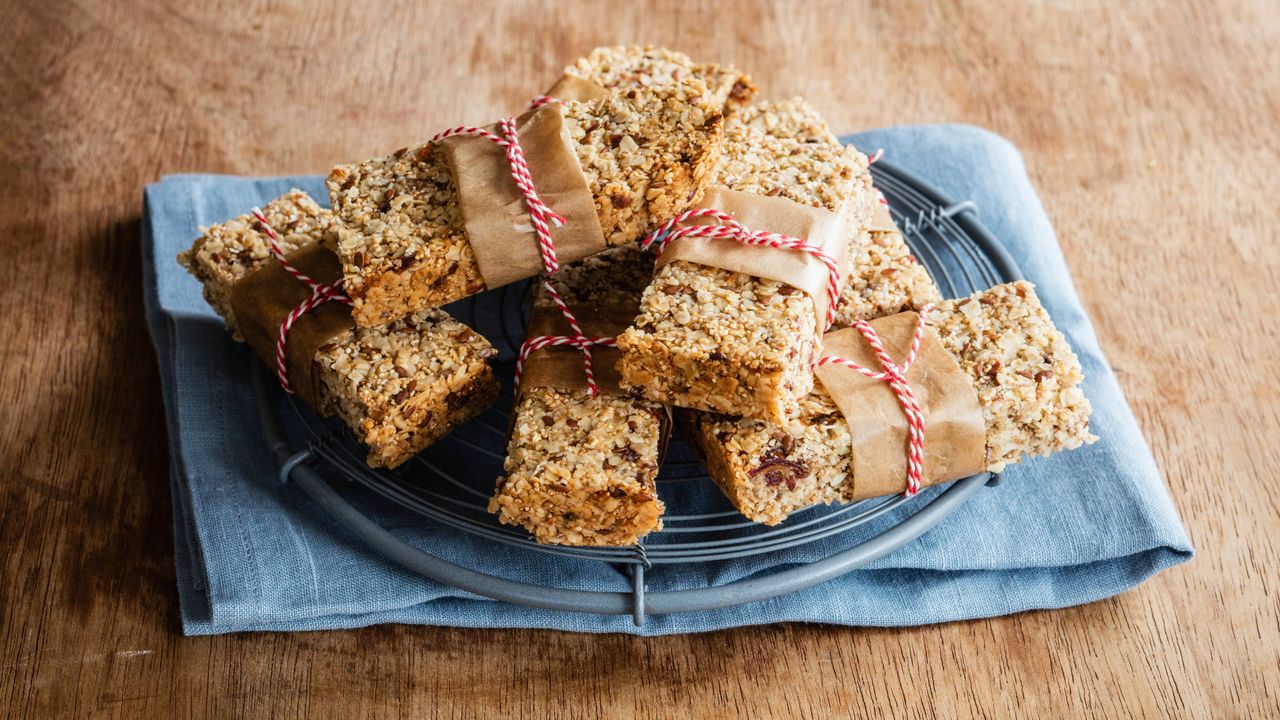 homemade energy bars on a wire cooling rack with brown paper and string tied around each bar