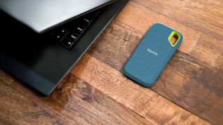 SanDisk Extreme Portable SSD 2TB next to laptop.