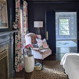 Blue doors in living room with light pink upholstered armchair and heavy drapes