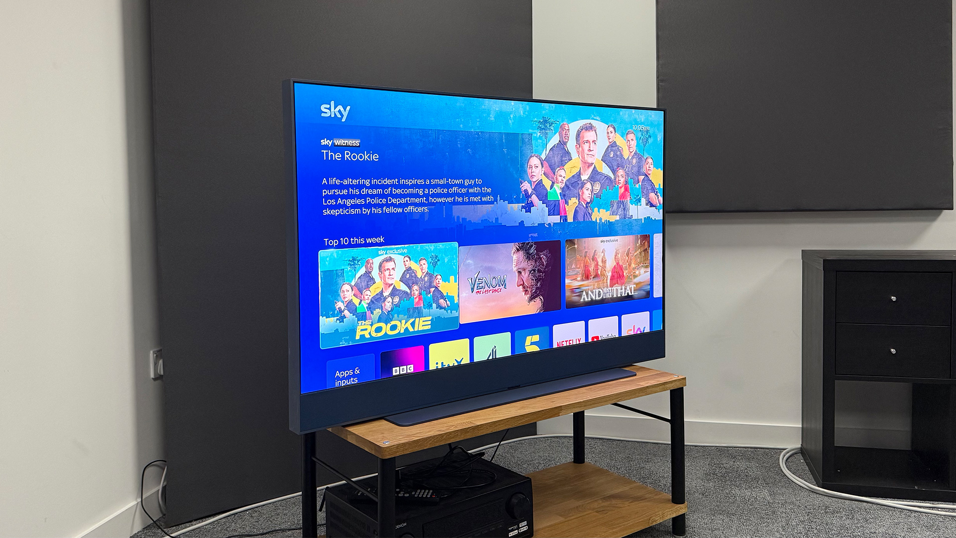 Sky Glass Gen 2 TV, soundbar and streaming service on wooden AV rack slight side angle