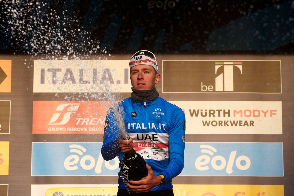 Overall leader Team UAE Emirates Tadej Pogacar of Slovenia sprays sparkling wine as he celebrates on the podium after the 5th stage of the Tirreno Adriatico cycling race 155 km from Sefro to Fermo on March 11 2022 Photo by Luca Bettini AFP Photo by LUCA BETTINIAFP via Getty Images
