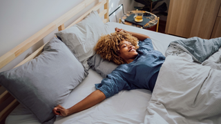 Woman having a stretch while waking up in bed