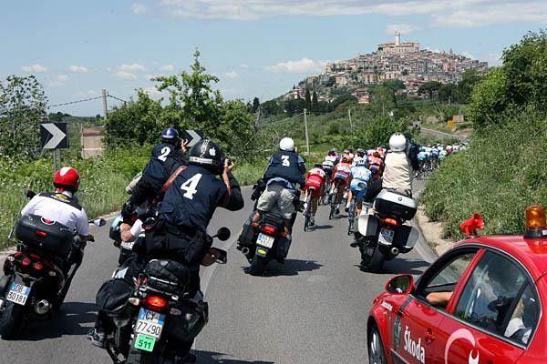 Media bikes and cars follow close behind the bunch.