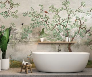 chinoiserie mural on wall behind white freestanding bath with large green plant in white pot, simple wooden shelf on wall and small wooden stool