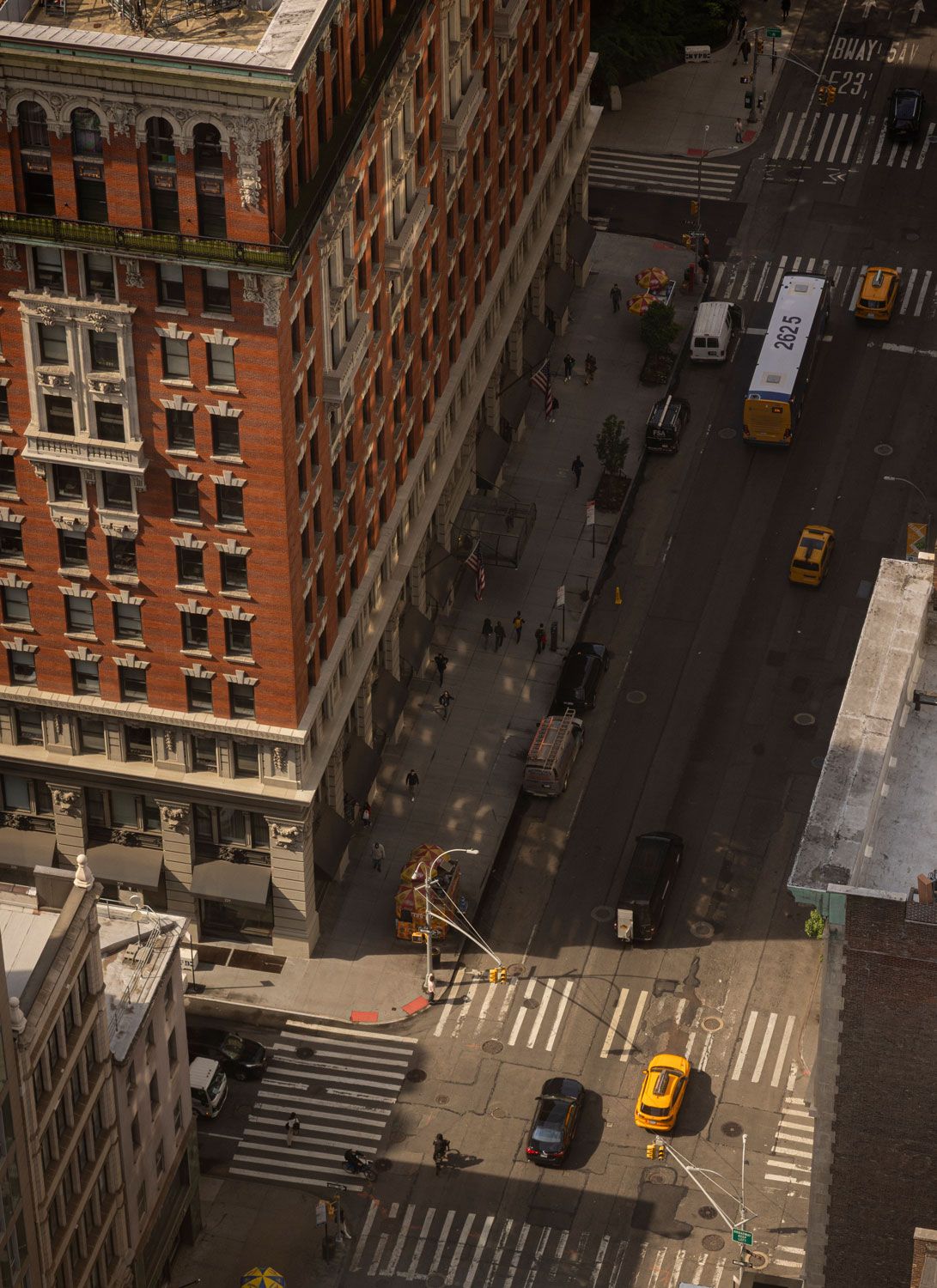 Elevated view from 262 Fifth Avenue looking down onto Manhattan streets, yellow taxis, pedestrians and surrounding historic buildings