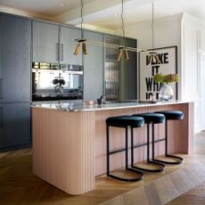 period and modern design pink and black kitchen with black bar stools and a pink breakfast bar