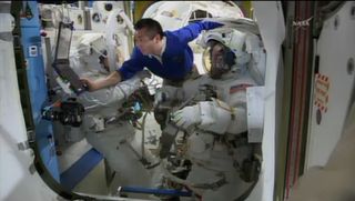 NASA astronauts Rick Mastracchio and Steve Swanson don their spacesuits with the help of Japanese astronaut Koichi Wakata (in blue) on April 23, 2014 ahead of a 2.5-hour spacewalk to replace a dead computer on the International Space Station.