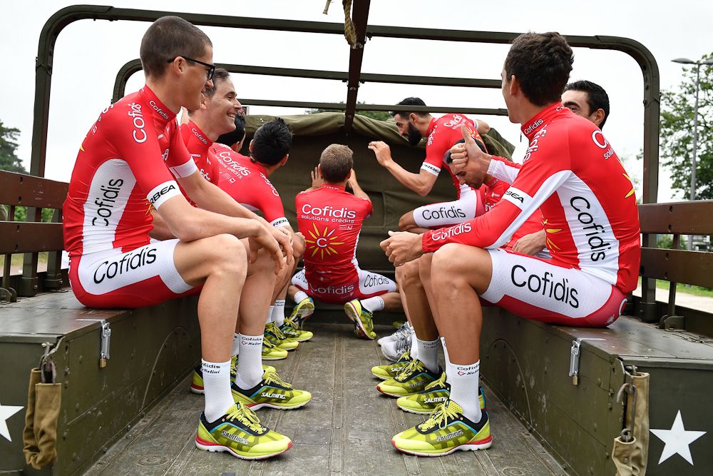 Riders of the France's Cofidis cycling team take part in a parade aboard an World War II US army vehicle during the team presentation
