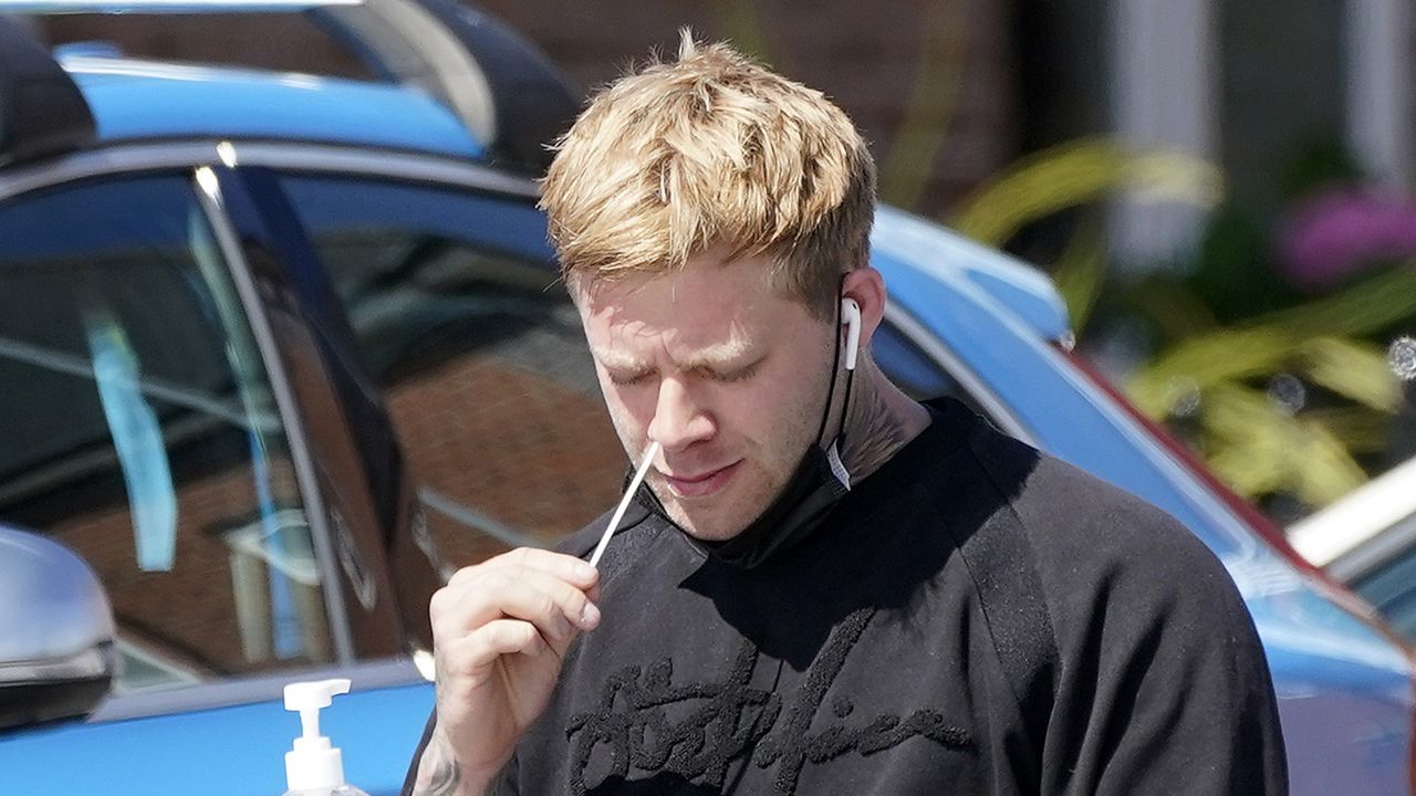 A man self administers a coronavirus swab test