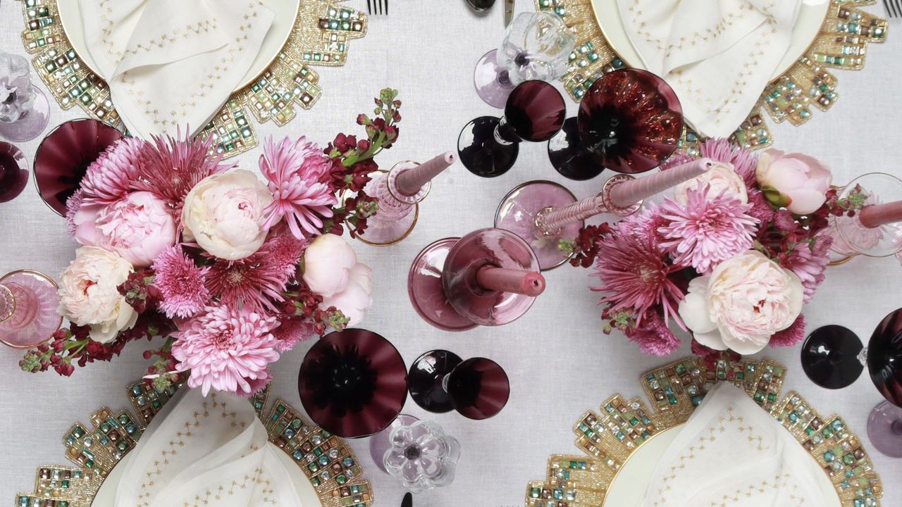 Pink and white themed table decor with flowers, candles and jewelled placemats