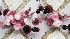 Pink and white themed table decor with flowers, candles and jewelled placemats