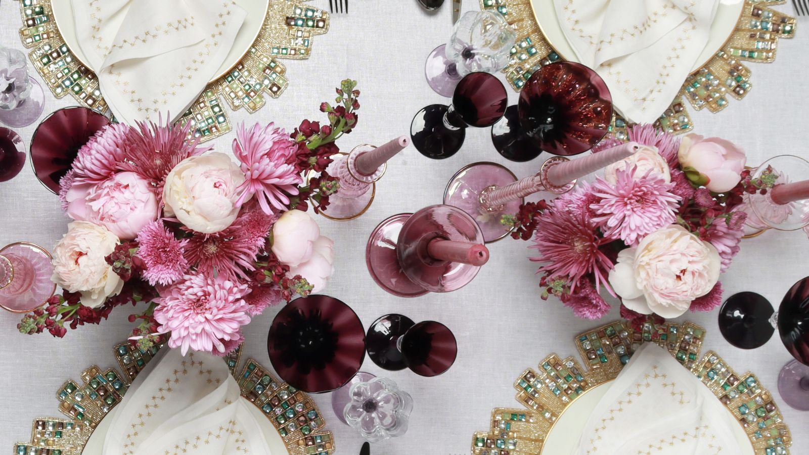 Pink and white themed table decor with flowers, candles and jewelled placemats