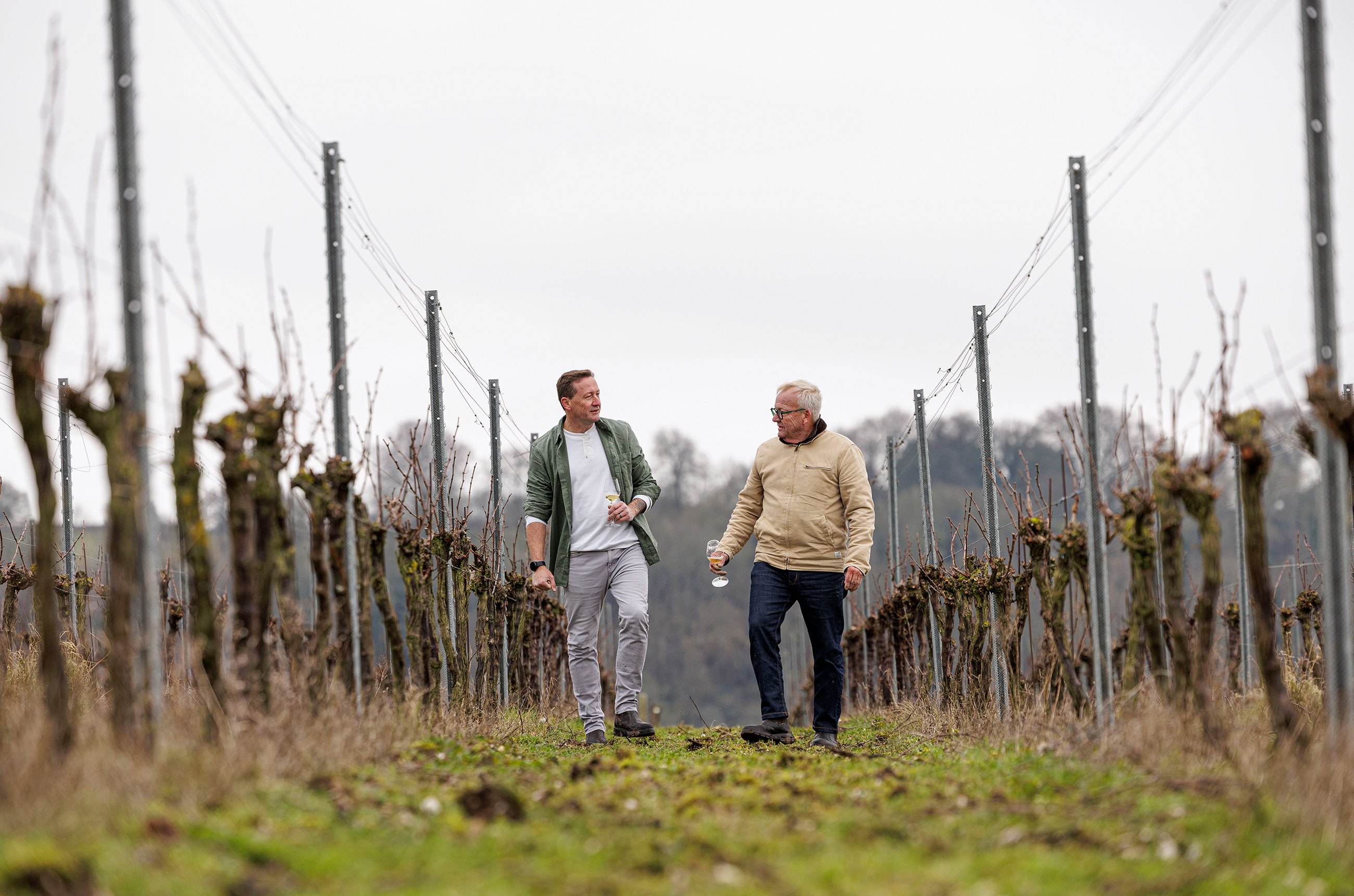 Two men, De Klerk and Ferreira, walking in between rows of vines on a wintry morning