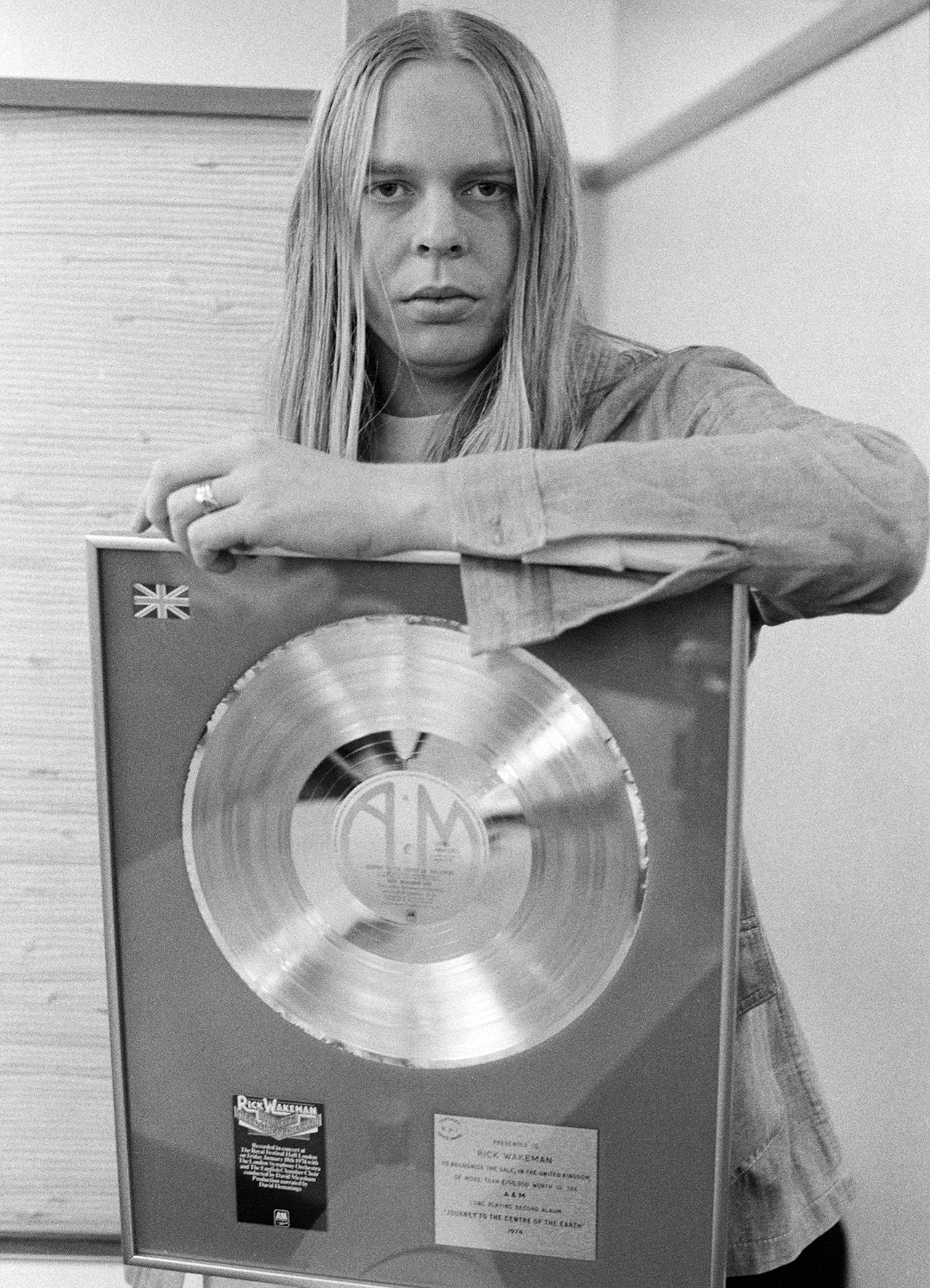 English keyboard player and composer Rick Wakeman, with an award from A&amp;amp;M Records for sales of his album 'Journey To The Centre Of The Earth', 10th January 1975. (Photo by Michael Putland/Getty Images)