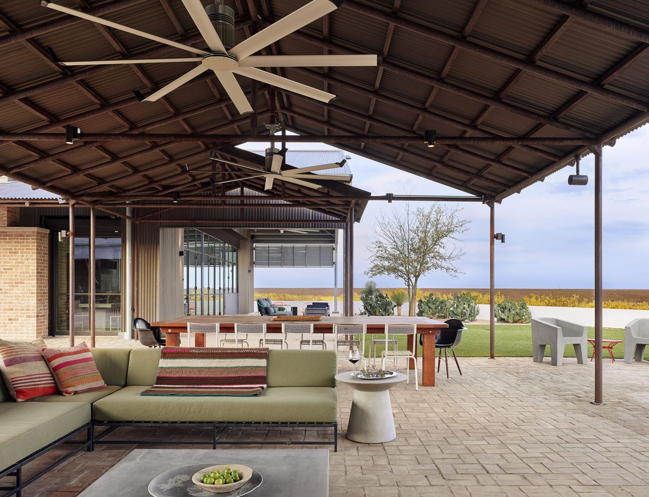 outdoor living room with striped throw and cushions by Ryan Street Architects