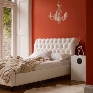 white bedroom with orange feature wall