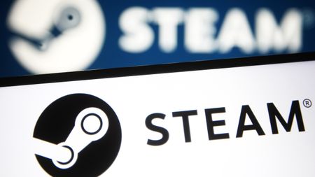 UKRAINE - 2021/07/24: In this photo illustration a Steam logo of a video game digital distribution service is seen on a smartphone and a pc screen.