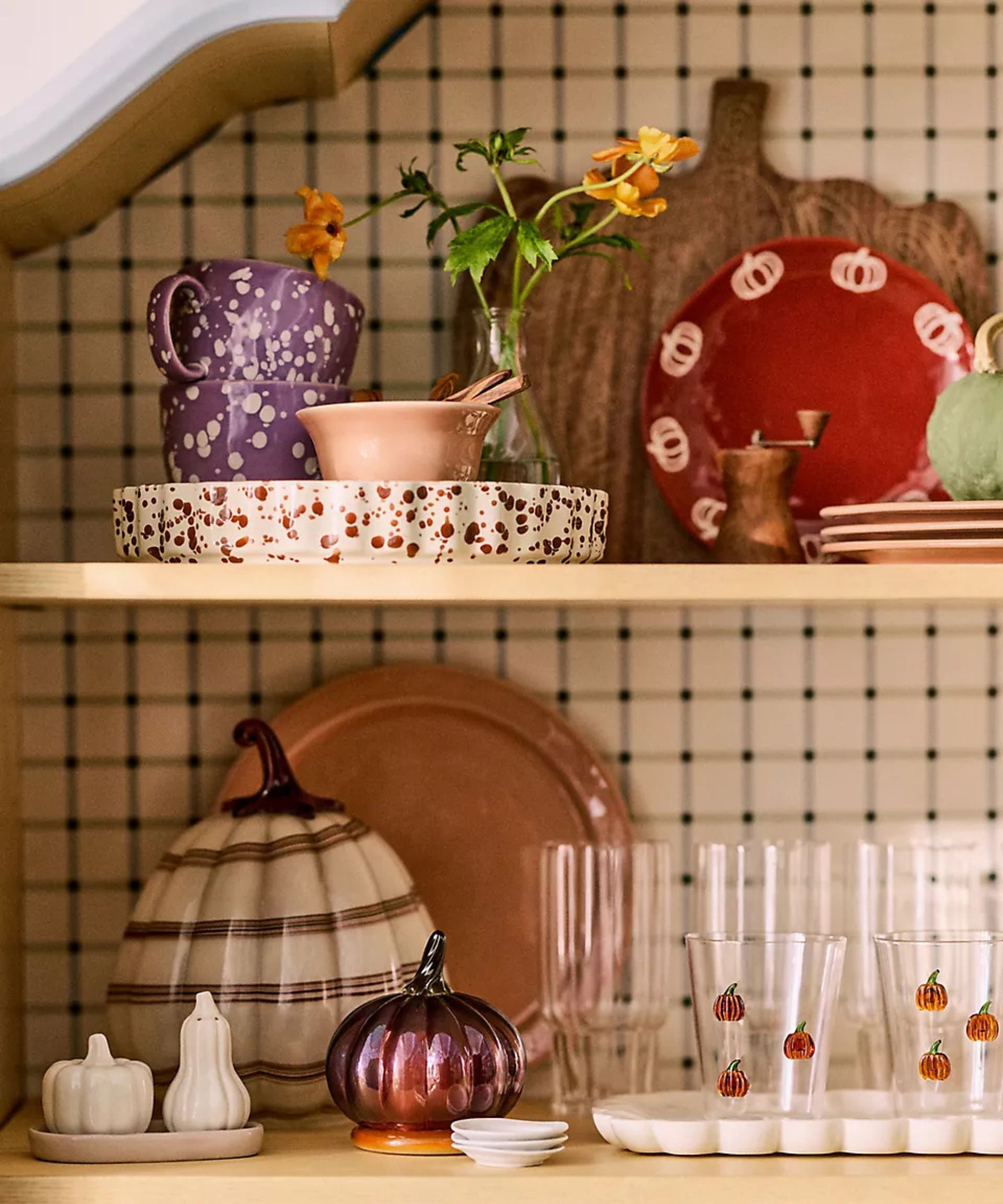 kitchen shelves styled with thanksgiving pumpkin themed decor, glassware, and tableware
