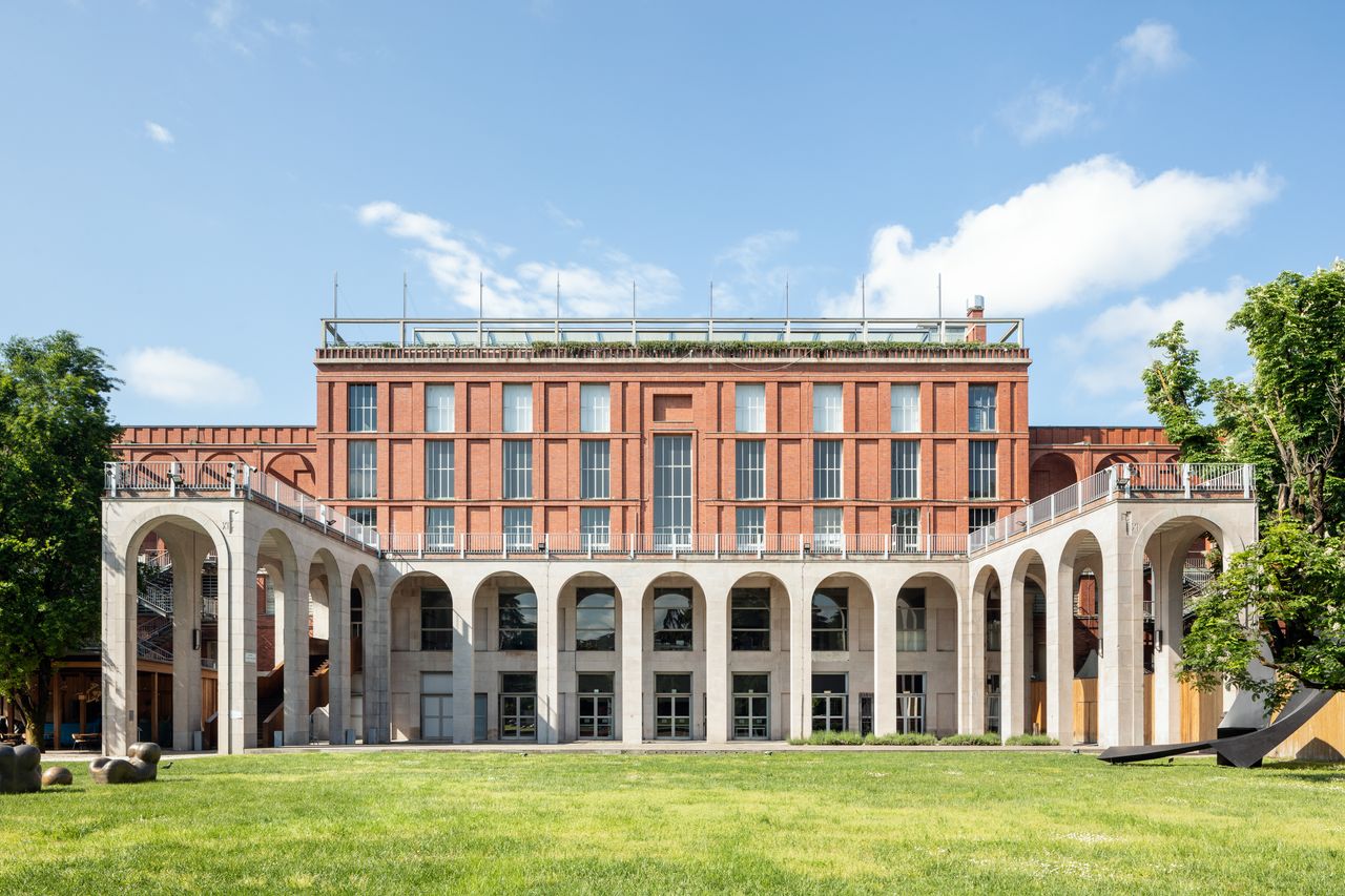 The arched historical facade of a museum is immersed in greenery.