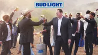 two men cheers each other next to a keg of Bud Light, there are other men cheersing in the background