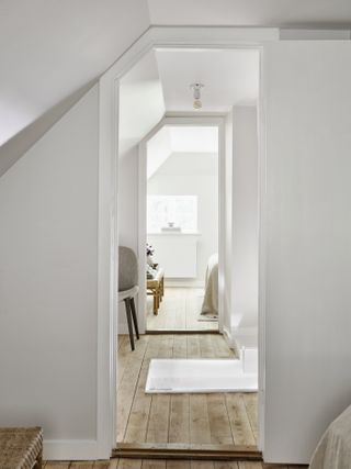 A white corridor with the original wooden floors visible