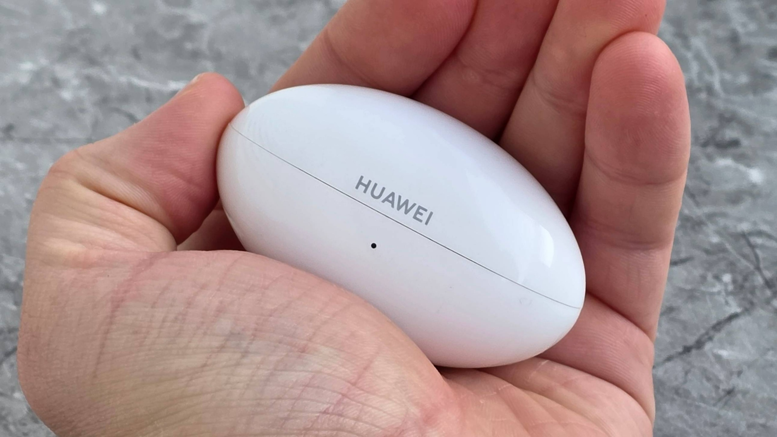 The Huawei FreeBuds Neo case in a man's hand.