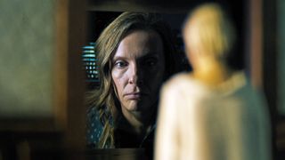 toni collette looks at a miniature in hereditary