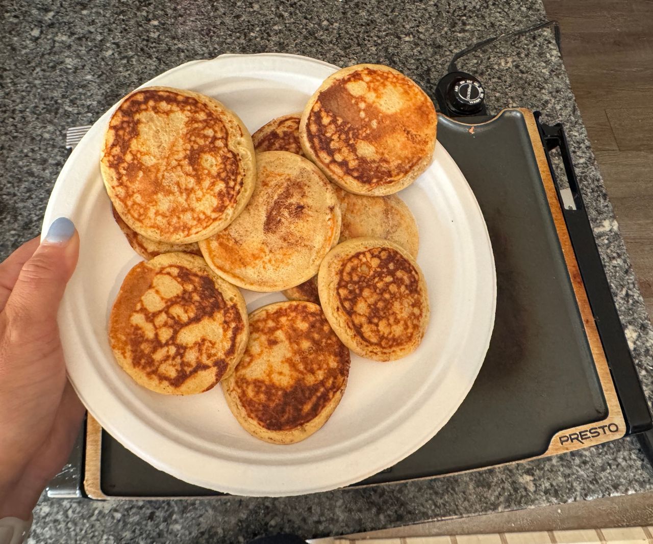 A plate of evenly browned mini pancakes.