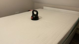 REM-Fit 500 Ortho hybrid mattress with a weight on it