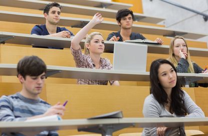 Students taking an active part in a lesson while sitting in a lecture hall